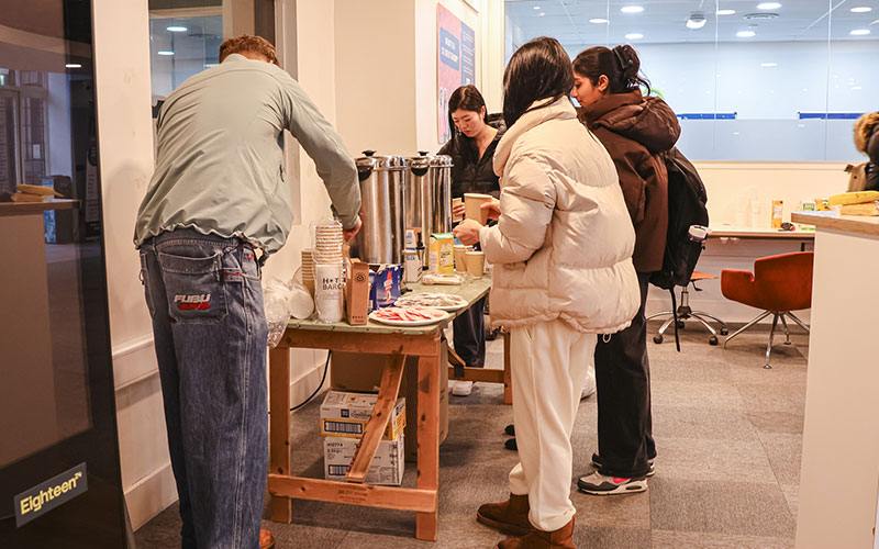 a photo of students queing up for hot drinks at a table